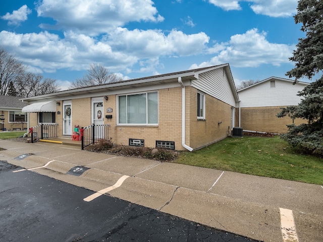 view of front of home with a front yard and central air condition unit