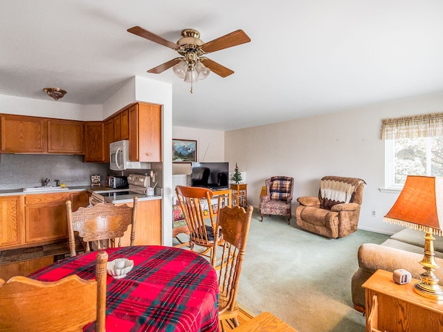 dining area featuring light carpet and ceiling fan