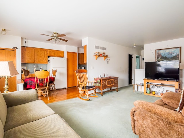 living room with ceiling fan and light hardwood / wood-style flooring