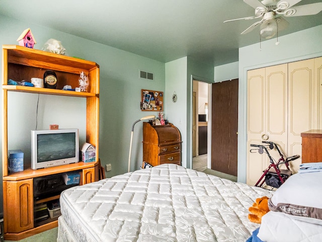 carpeted bedroom with ceiling fan and a closet