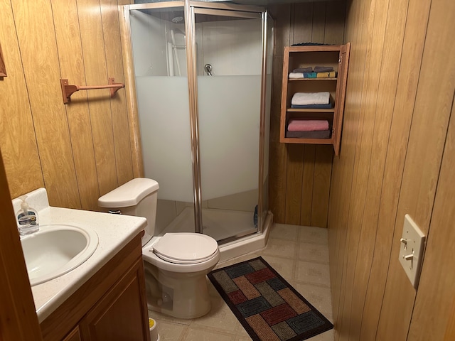 bathroom featuring vanity, wood walls, toilet, and a shower with door