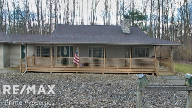 view of front of property featuring a shingled roof and a chimney