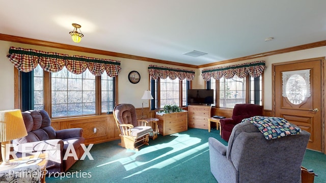 sitting room featuring visible vents, wood walls, ornamental molding, carpet flooring, and wainscoting