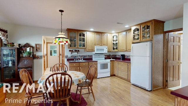 kitchen with white appliances, light wood-style flooring, glass insert cabinets, and visible vents