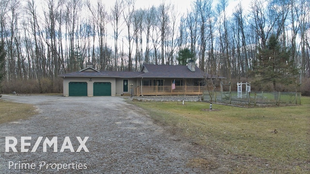 view of front of house with a front lawn, an attached garage, driveway, and a chimney