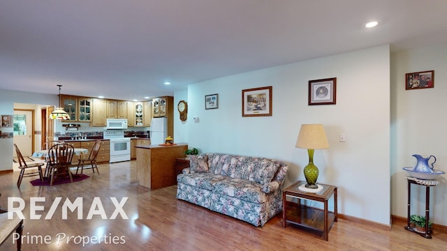 living area with light wood finished floors, recessed lighting, and baseboards