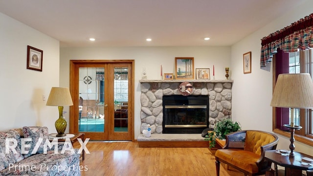 living room with recessed lighting, a fireplace, french doors, and wood finished floors