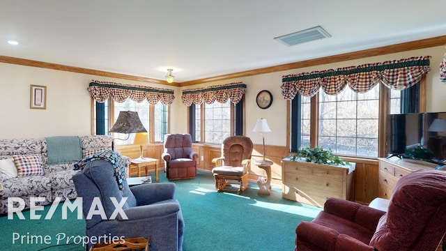 living room featuring carpet flooring, visible vents, a wainscoted wall, and ornamental molding