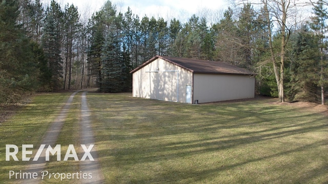 view of outbuilding featuring a view of trees and an outdoor structure