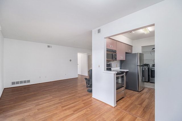 kitchen with light hardwood / wood-style floors and appliances with stainless steel finishes