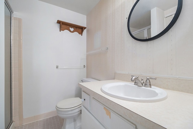 bathroom featuring tile patterned floors, a shower with door, vanity, and toilet