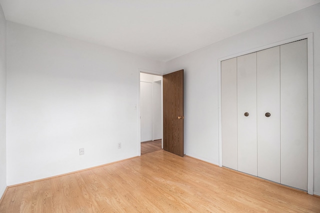 unfurnished bedroom with light hardwood / wood-style floors and a closet