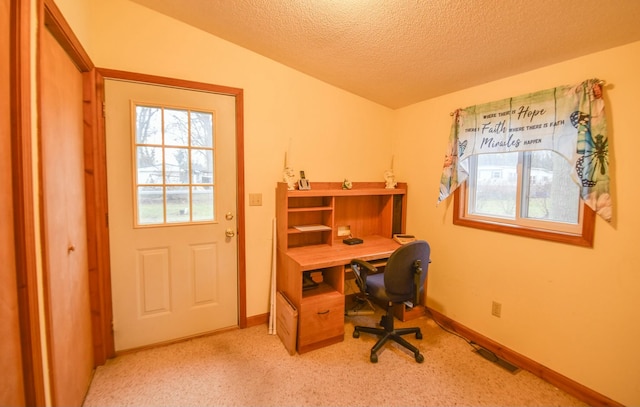 carpeted office space with a textured ceiling and vaulted ceiling