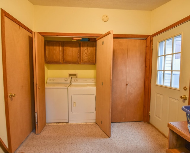 laundry area with separate washer and dryer, light colored carpet, and cabinets