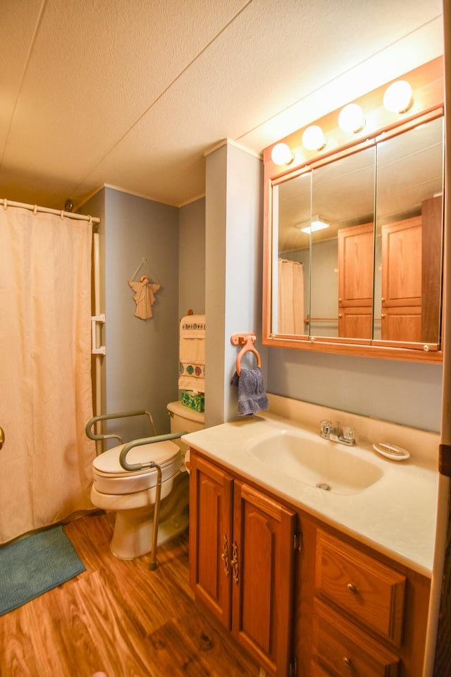 bathroom featuring a textured ceiling, vanity, hardwood / wood-style flooring, and toilet