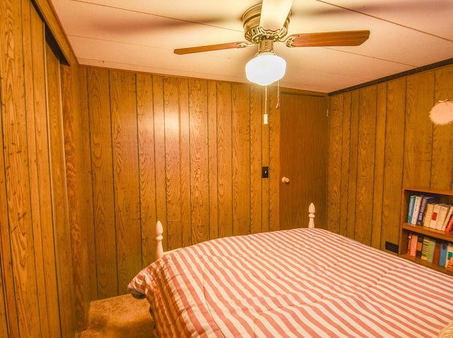 bedroom with wood walls and ceiling fan