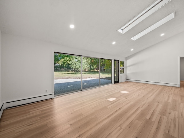 spare room featuring light wood-type flooring, vaulted ceiling, and baseboard heating