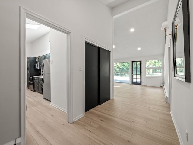 hallway with light hardwood / wood-style floors and baseboard heating