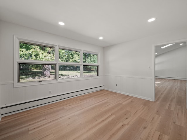 spare room featuring a wealth of natural light, light hardwood / wood-style flooring, and baseboard heating