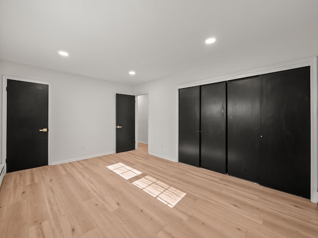 unfurnished bedroom featuring light hardwood / wood-style floors and a closet