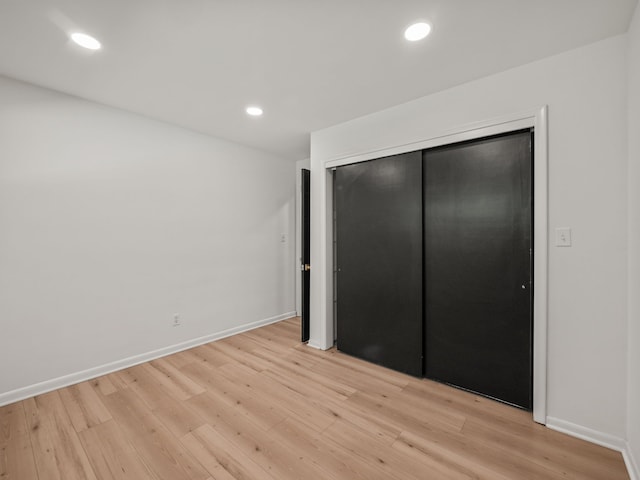 unfurnished bedroom featuring light wood-type flooring and a closet