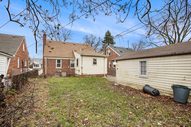 back of property with central AC and a yard