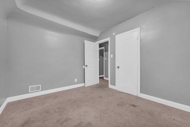 empty room featuring carpet floors and vaulted ceiling