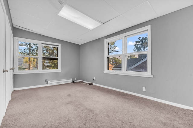 carpeted empty room with baseboard heating and a wealth of natural light