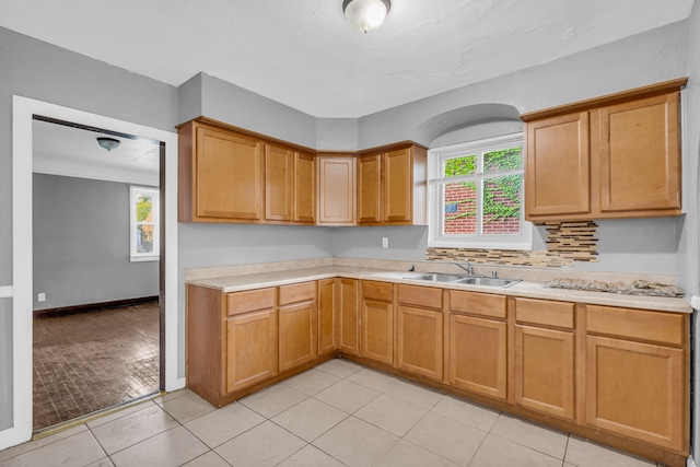 kitchen featuring a healthy amount of sunlight, light tile patterned floors, and sink