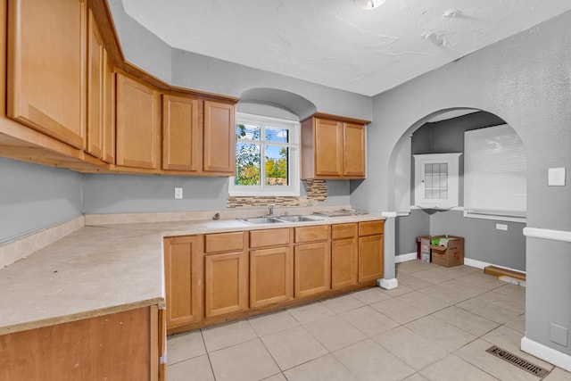 kitchen featuring light tile patterned floors and sink