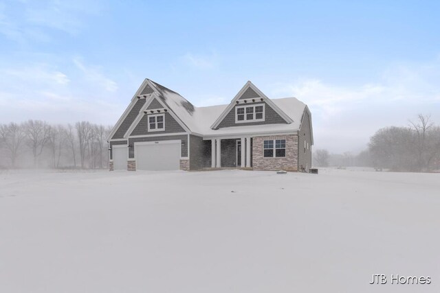 craftsman-style house featuring a garage and stone siding