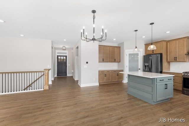 kitchen with stainless steel appliances, recessed lighting, light countertops, a kitchen island, and wood finished floors