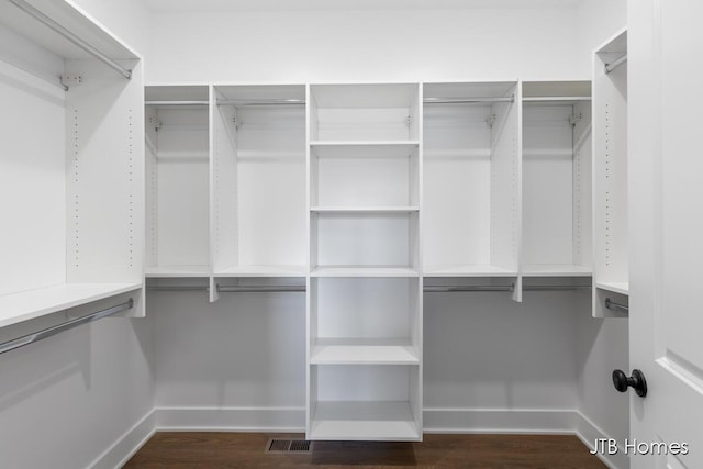 spacious closet featuring visible vents and dark wood finished floors