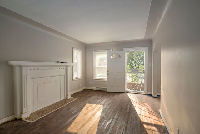 entrance foyer with dark hardwood / wood-style floors and a tiled fireplace