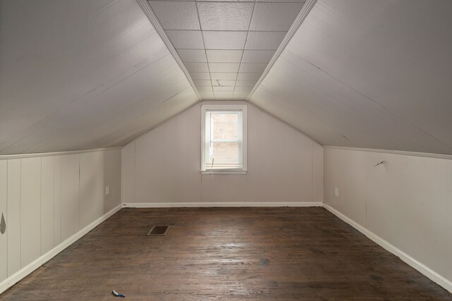 additional living space featuring dark wood-type flooring and vaulted ceiling