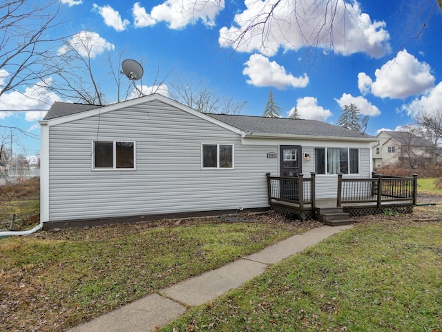 view of front of property with a wooden deck and a front yard