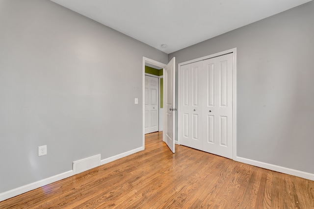 unfurnished bedroom with a closet and light hardwood / wood-style floors