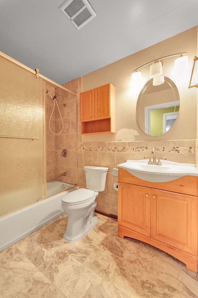 full bathroom featuring vanity, toilet, tile walls, and tiled shower / bath