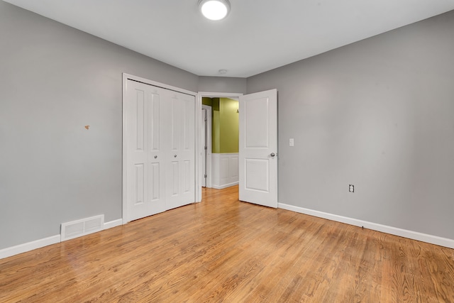 unfurnished bedroom with light hardwood / wood-style floors and a closet