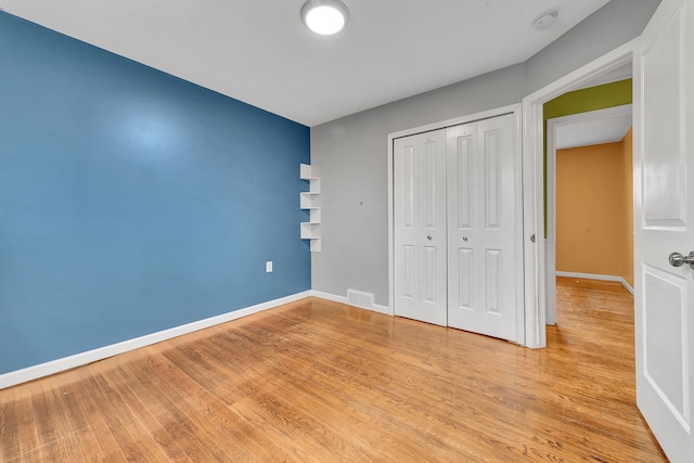 unfurnished bedroom with light hardwood / wood-style flooring and a closet