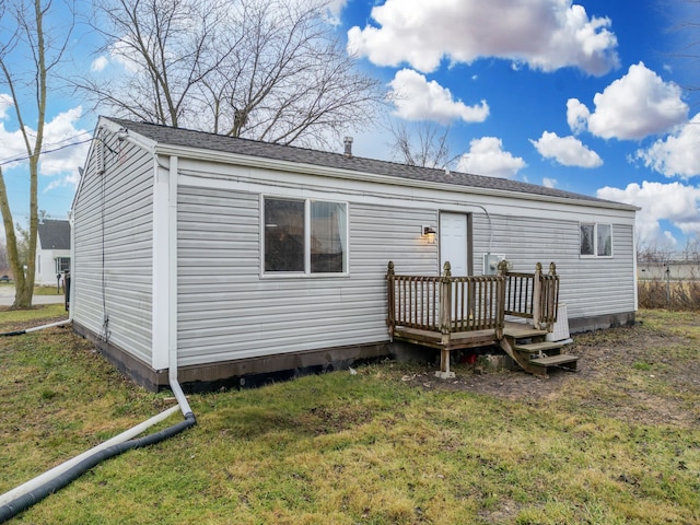 rear view of property featuring a lawn