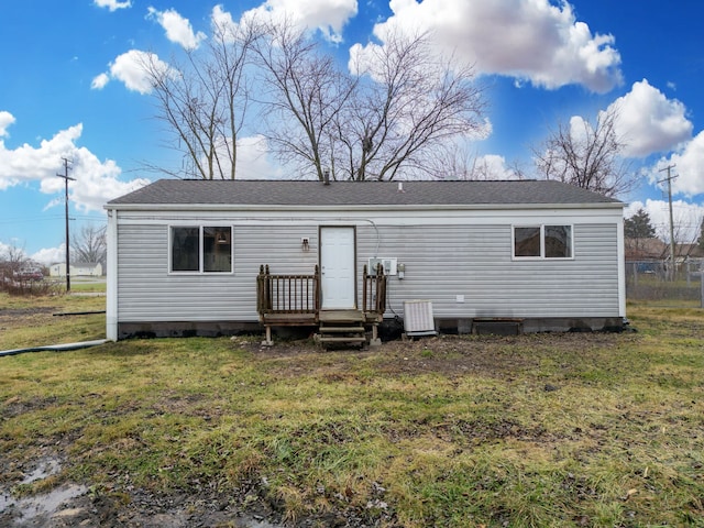 back of property featuring a lawn and central air condition unit