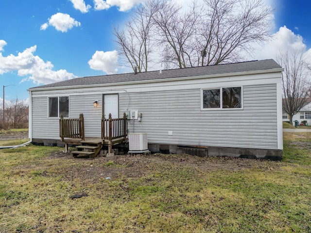 back of property featuring central AC unit and a lawn