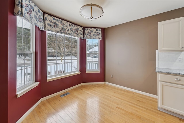 unfurnished dining area featuring light wood-type flooring