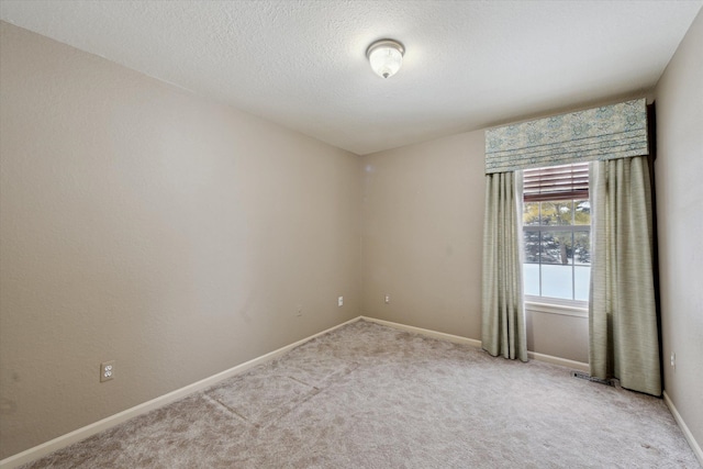 carpeted spare room featuring a textured ceiling