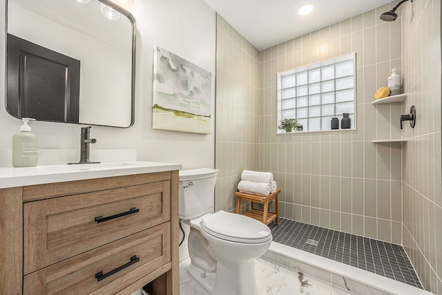 full bathroom featuring toilet, a tile shower, marble finish floor, and vanity