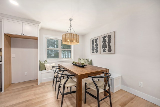 dining room featuring breakfast area, baseboards, and light wood-style flooring