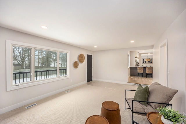 sitting room with recessed lighting, baseboards, visible vents, and light carpet