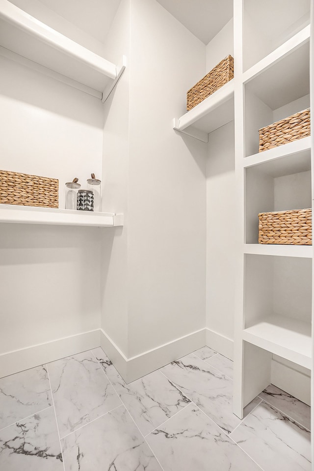 walk in closet with marble finish floor