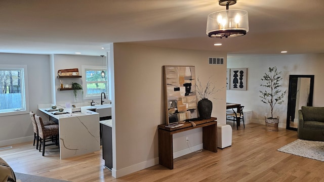 living area featuring light wood-style floors, recessed lighting, and visible vents